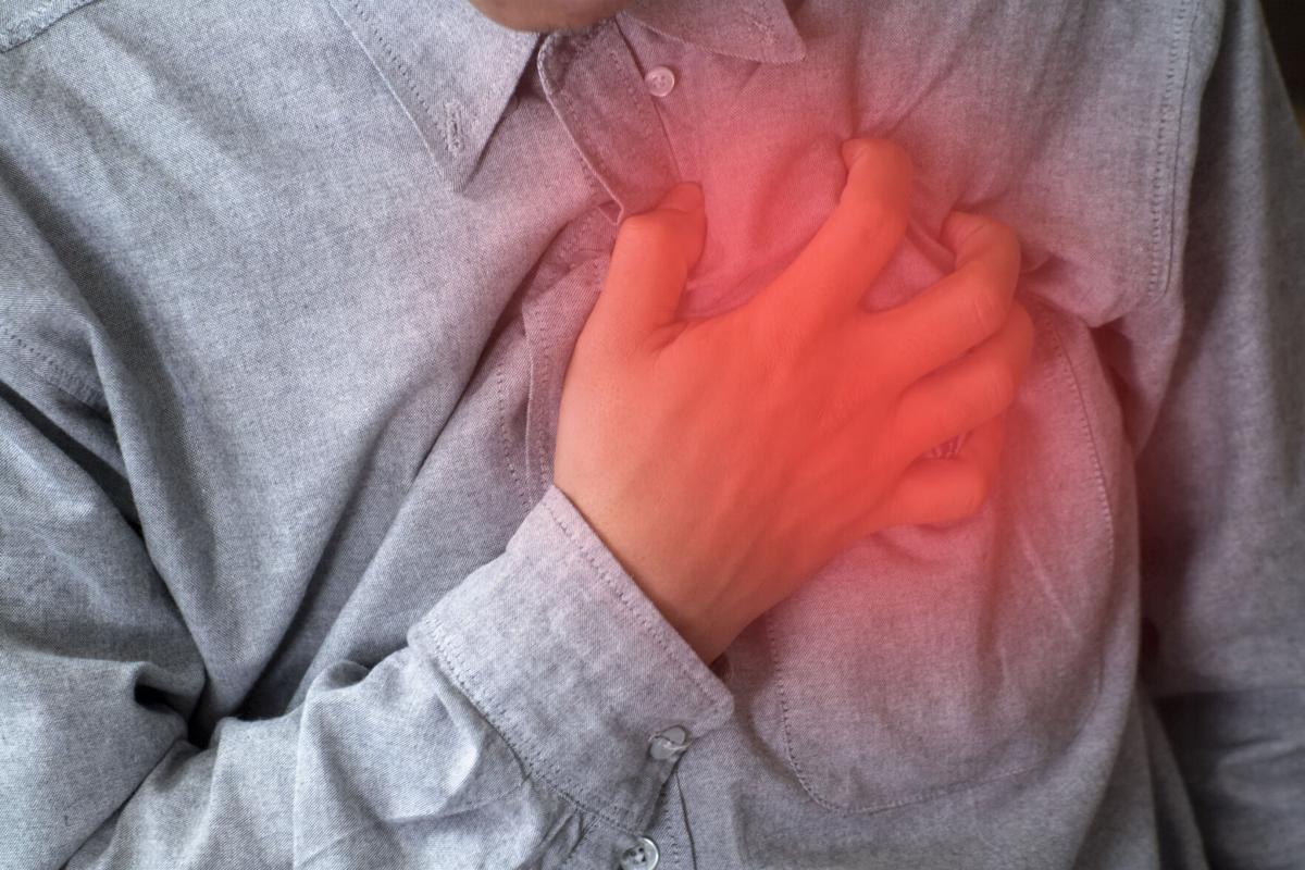 Severe heartache, man suffering from chest pain, having heart attack or painful cramps, pressing on chest with painful expression.