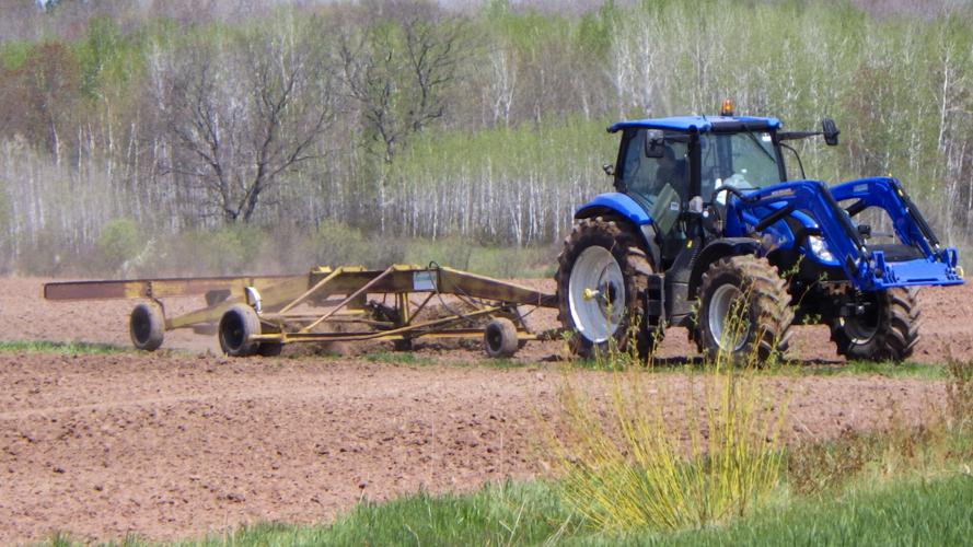 Tractor plows tills in field