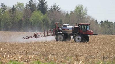 Farmer spraying field late spring