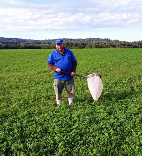 Tim Boerner with net in alfalfa field