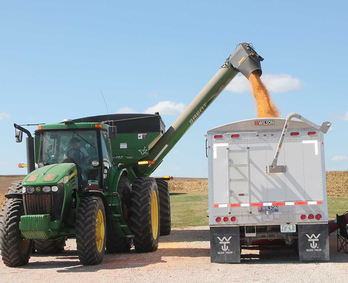 field tractor unloads grain