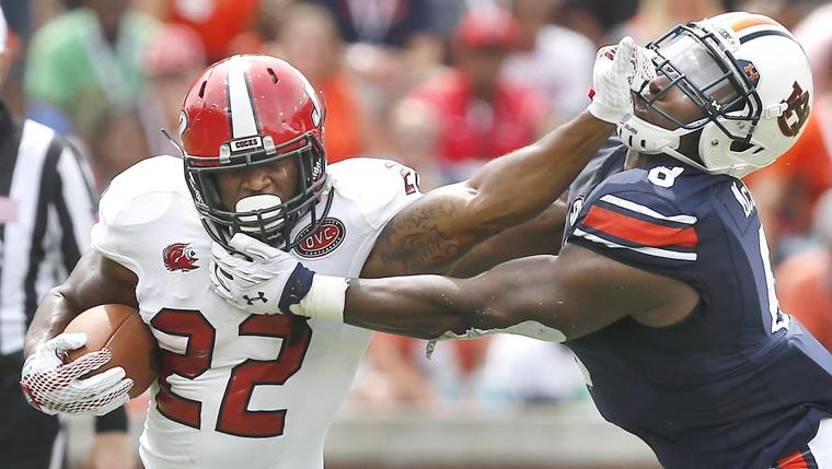 Jacksonville State running back Josh Clemons stiff arms Auburn linebacker Cassanova McKinzy during the JSU at Auburn football game. Photo by Stephen Gross / The Anniston Star