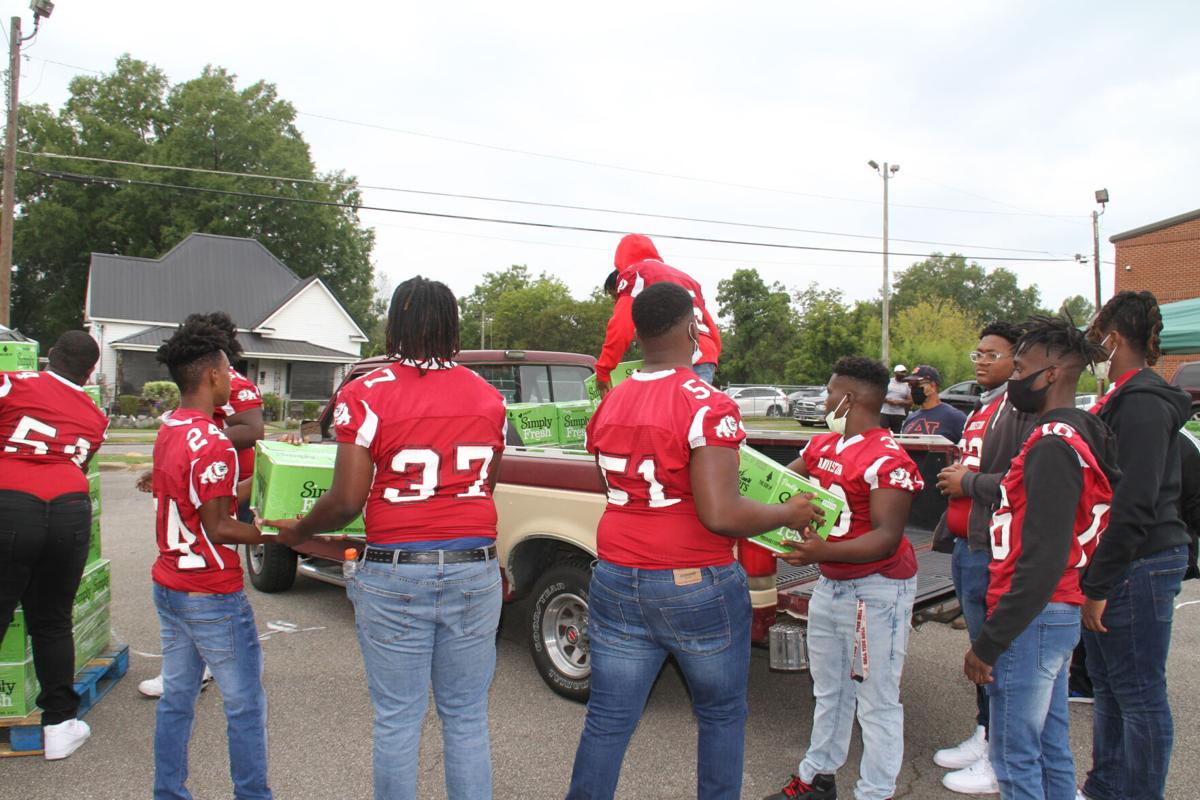Anniston High football team helps with food giveaway | Faith