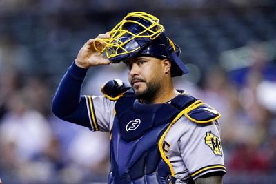 Seattle Mariners' Omar Narvaez removes his batting helmet in the dugout as  he greets teammates after hitting a three-run home run during the third  inning of a baseball game against the Boston