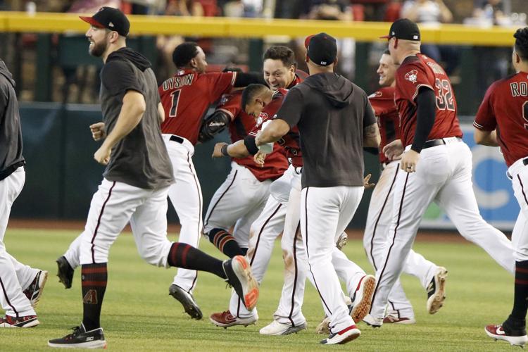 Arizona Diamondbacks' Tim Locastro gets a banana cream pie in the face from  his teammate Adam Jones' son Axel after getting the game winning hit  against the San Diego Padres during the