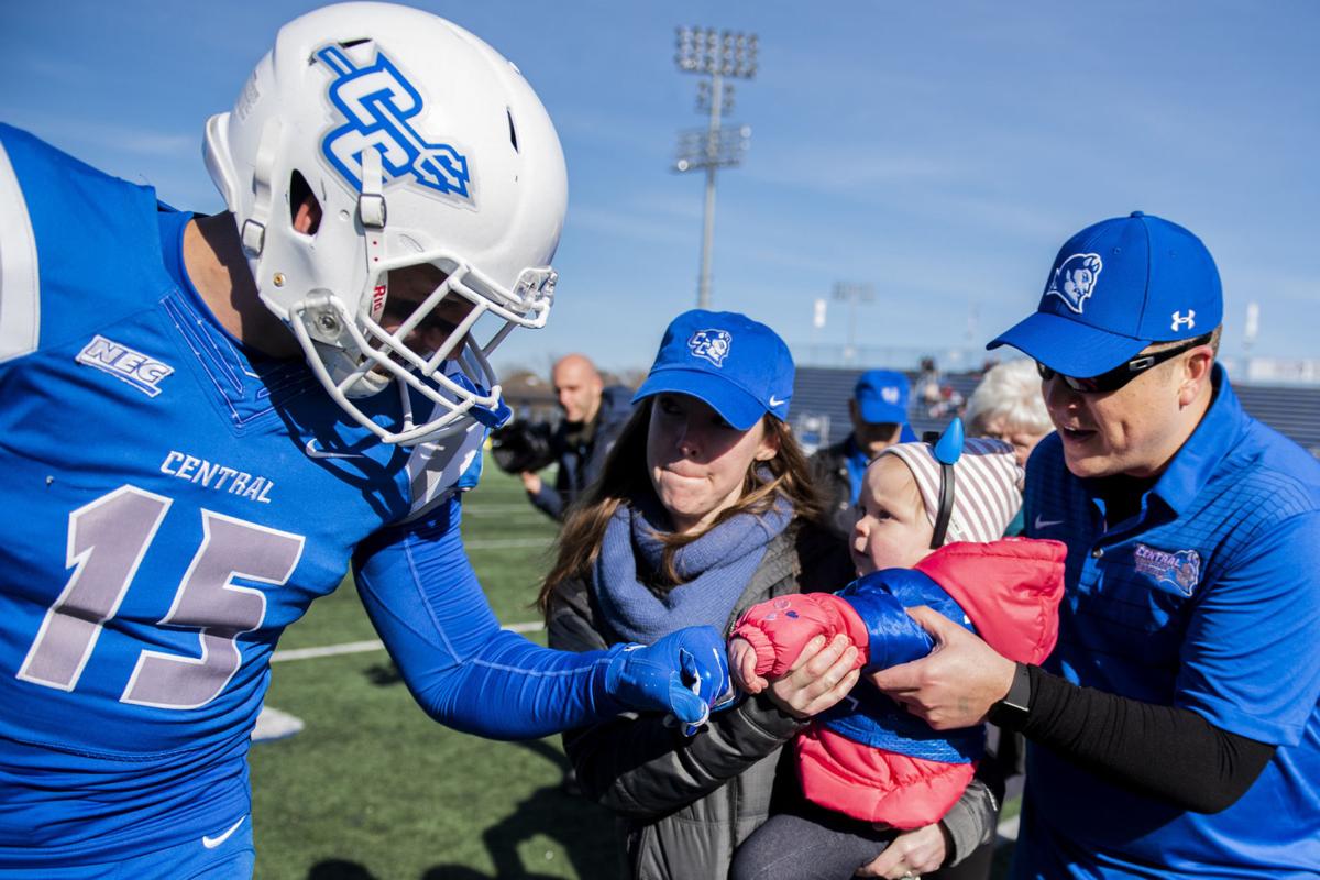 CCSU linebacker Mike Mushaw fist bumps Eleanor, almost 2, as she's held by her mom, Jess, and helped by her dad, Elan, after she tossed the coin before Saturday's 38-31 overtime victory over St. Francis in New Britain on Saturday, Nov. 9, 2019.