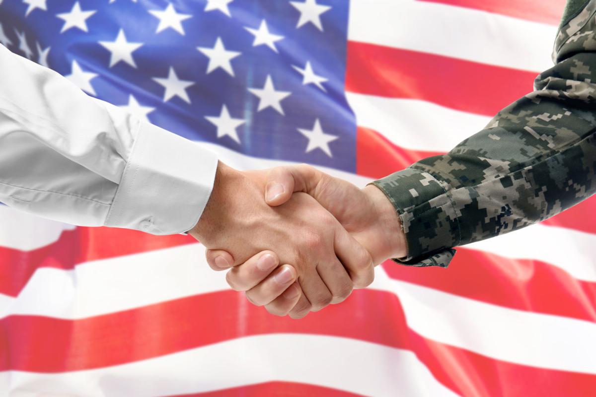 USA military man in uniform and civil man in suit shaking hands with national flag on background - Liberia