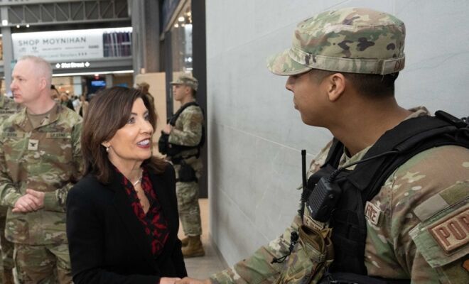 Spanish Translation: Protegiendo a los Neoyorquinos: La Gobernadora Hochul se une a la Guardia Nacional de Nueva York en la Sala de Trenes Moynihan para Destacar las Mejoras de Seguridad en Medio de las Operaciones Militares en Curso en el Extranjero