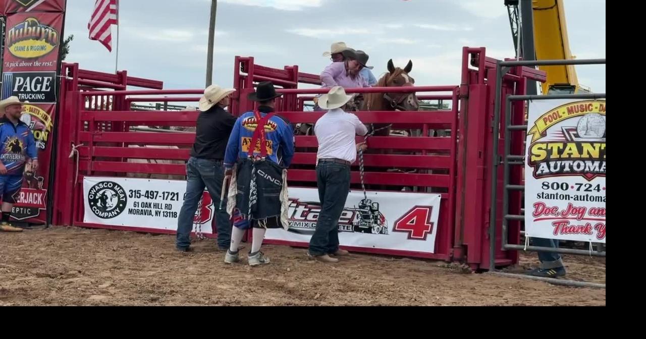 Cowgirl bronc busting at Stampede Rodeo in Throop