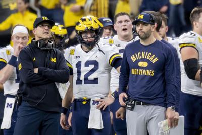Michigan head coach Jim Harbaugh, quarterback Cade McNamara, and quarterbacks coach Matt Weiss during the fourth quarter of the Big Ten championship game against Iowa at Lucas Oil Stadium in Indianapolis, Dec. 5, 2021.