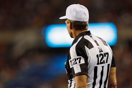 NFL referees discuss a penalty flag thrown during the second half of an NFL  playoff game betwee …