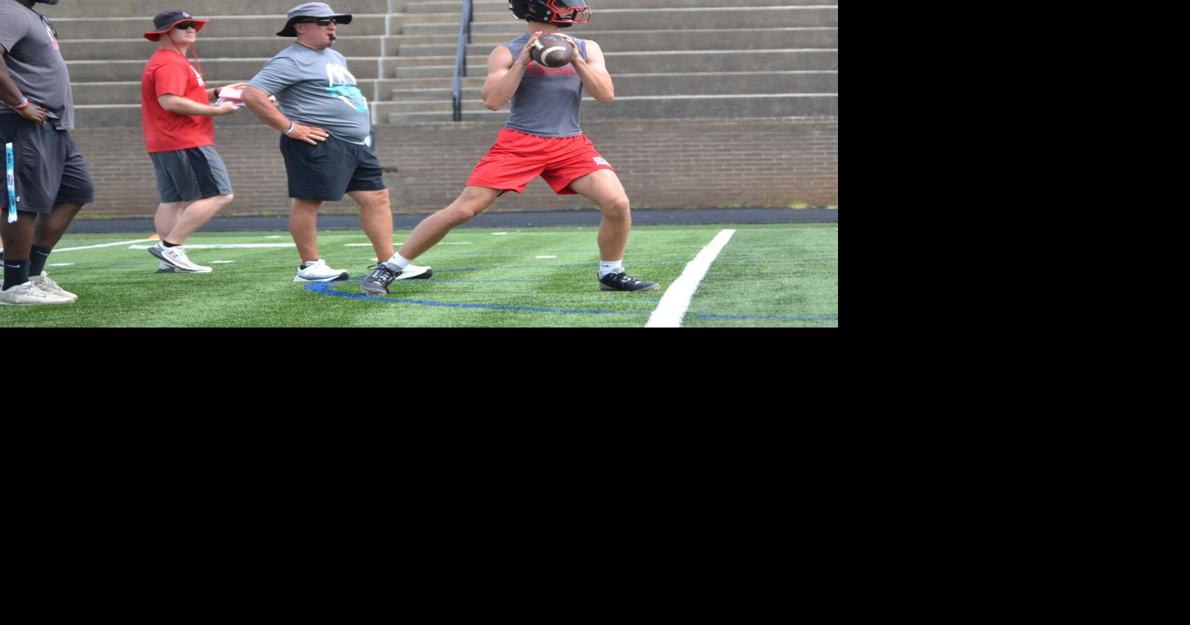 Hudson Manis looks for an open receiver in 7-on-7 action against St. Stephens as coaches Ethan Farmer and Neal Gragg look on.jpg