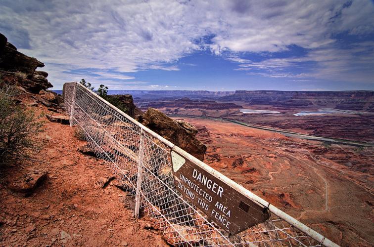 An "unprotected" sign on Anticline Overlook looking down on a potash works near Canyonlands National Park, Utah. Photo by Tim Petersen