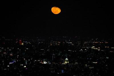 The moon is seen over the city of Beijing