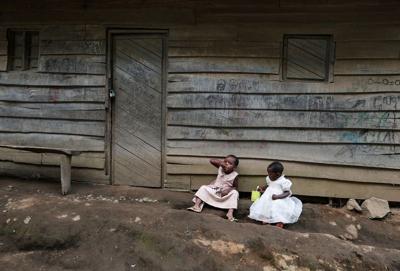 FILE PHOTO: Girls eat outside their parent's house in Mushaki