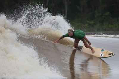 Brazilian surfer Sergio Laus rides the thunderous pororoca tidal bore wave on the Mearim River, in the Amazon jungle