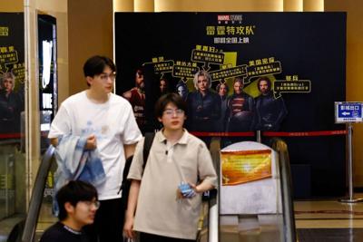 People ride on escalator near an installation promoting the Marvel Studios' ''Thunderbolts'', at a movie theatre in Beijing