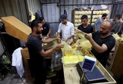 Palestinian workers pack bread in a bakery that returned to operation after being closed due to a flour shortage, in Deir Al-Balah