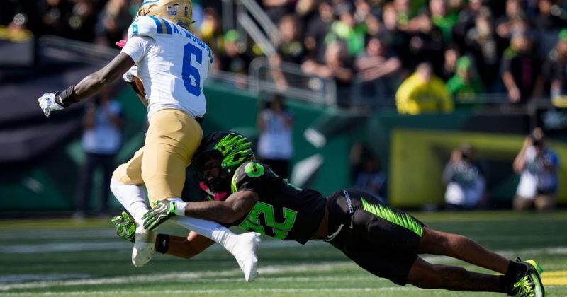 Oregon defensive back Devin Jackson tackles UCLA running back Anthony Woods as the Oregon Ducks host the UCLA Bruins on Oct. 10, 2026, at Autzen Stadium in Eugene, Oregon.