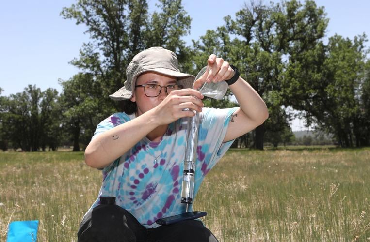   Jay Wells, an undergraduate at NAU studying geology, fills a mini disk infiltrometer to measure how quickly water is absorbed into the soil as part of his research project studying invasive plant species and soil property correlations at the Historic Hat Ranch on Thursday, June 20. Hattie Loper, Arizona Daily Sun 