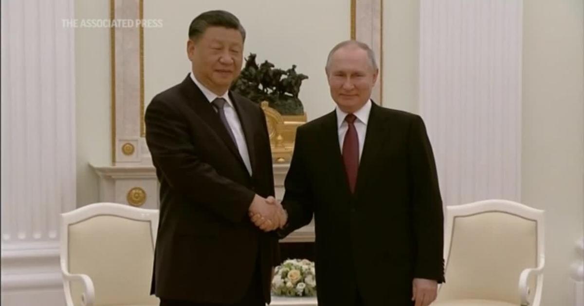 Putin gives Xi a warm greeting in Moscow