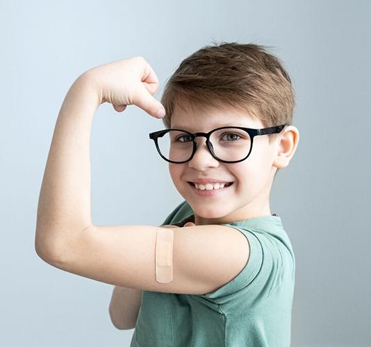 Cute boy vaccinated against coronavirus infection. Vaccination against covid-19. Sputnik-V. Copy space.