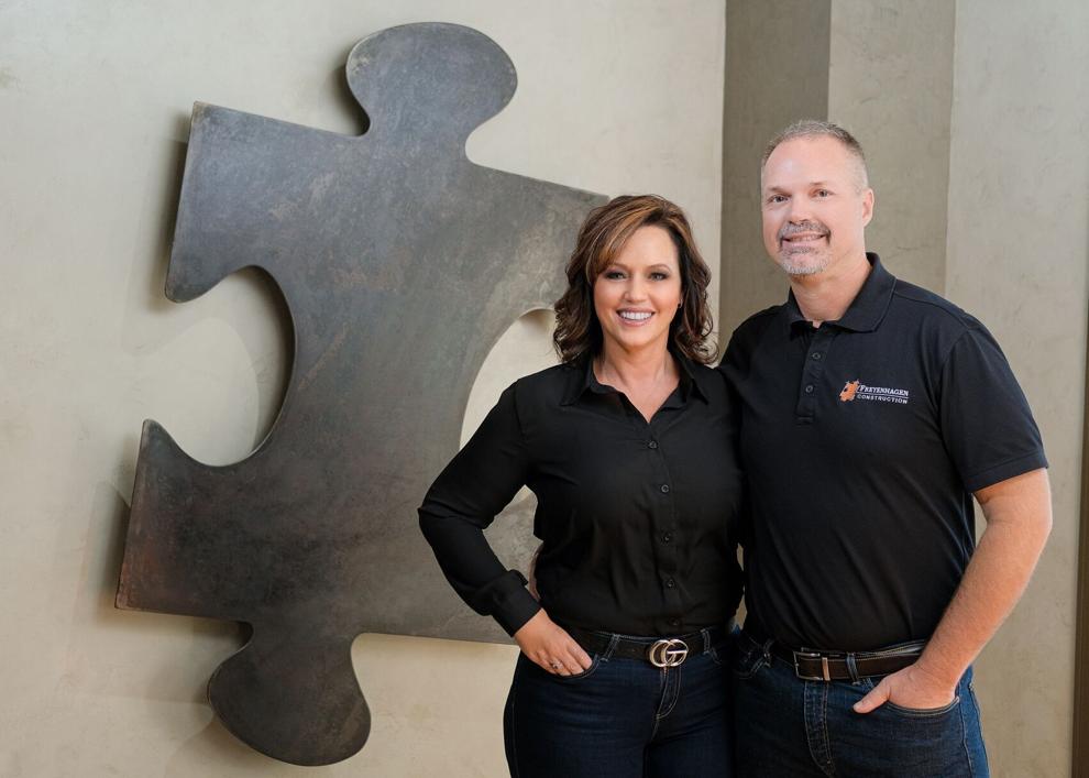 Jeremy and Angie posing next to the Freyenhagen Construction logo