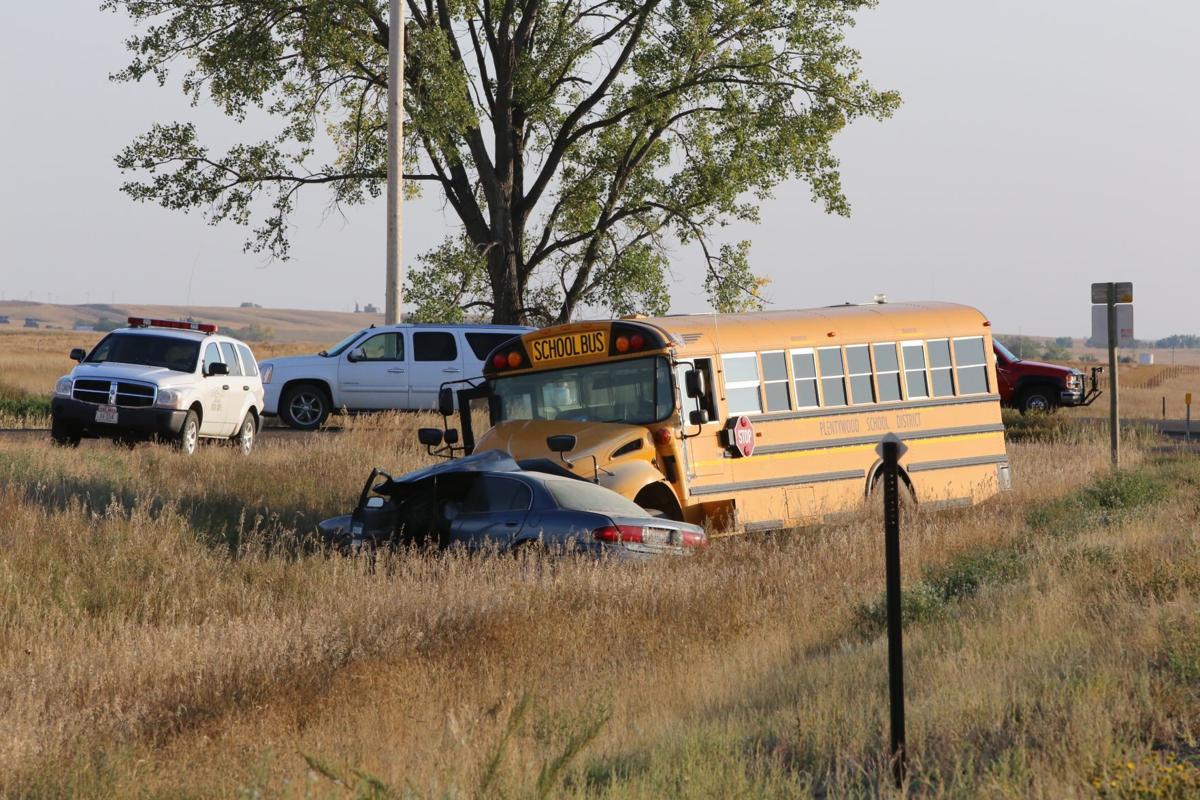 1 hospitalized after car turns in front of school bus carrying