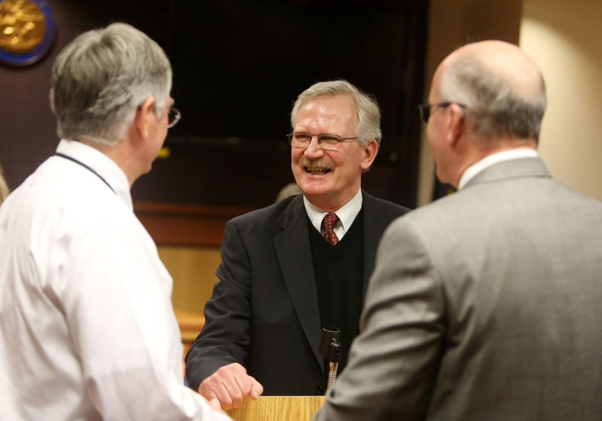 Sitting judge gives new judge the robe off his shoulders for his