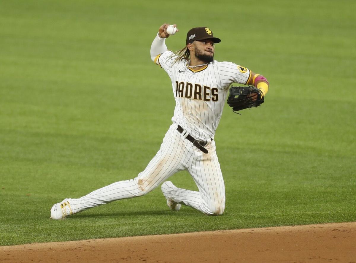 Fernando Tatis Jr. of the San Diego Padres tries to throw out Corey Seager of the Los Angeles Dodgers in the 3rd inning during Game 3 of the NLDS at Globe Life Field in Arlington, Texas on Thursday, Oct. 8, 2020.