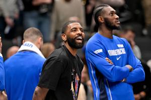 Dec 12, 2025; Dallas, Texas, USA; Dallas Mavericks guard Kyrie Irving (11) jokes with his teammates during the second half against the Brooklyn Nets at the American Airlines Center. Mandatory Credit: Jerome Miron-Imagn Images