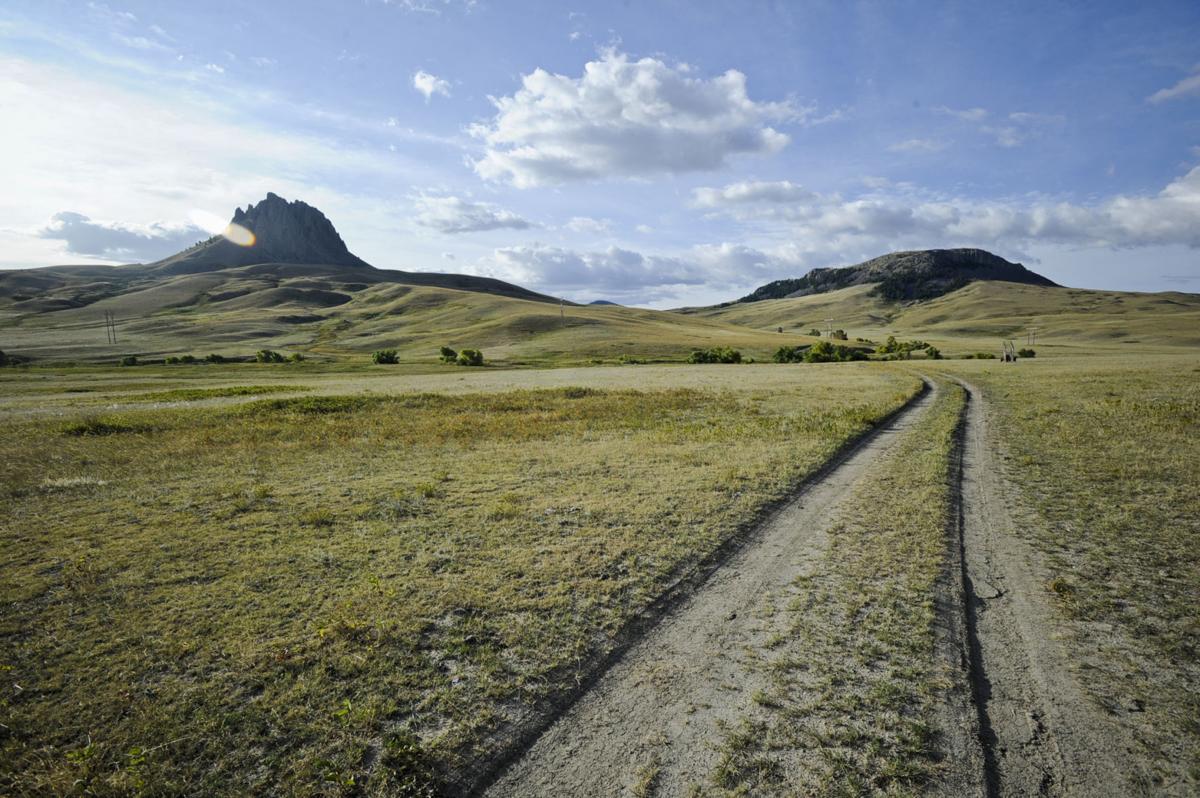 A two-track road winds through the conservation easement between Birdtail Butte, left, and Lionshead Butte.