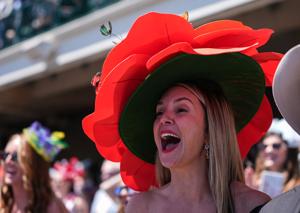 Courtney Cox of Louisville cheers during the second race while wearing a big flower hat at Thurby at Churchill Downs during Kentucky Derby week. April 30, 2026