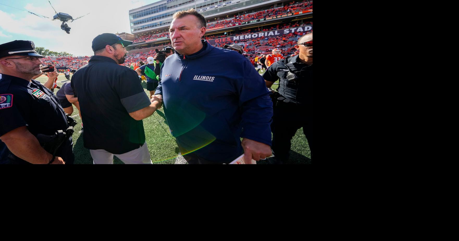 Coverage image for: Ohio State Buckeyes head coach Ryan Day shakes hands with Illinois Fighting Illini head coach Bret Bielema following the Buckeyes' 34-16 win in the NCAA football game at Gies Memorial Stadium in Champaign on Oct. 11, 2025.