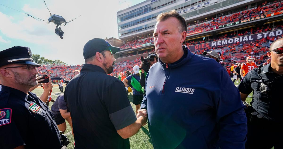 Coverage image for: Ohio State Buckeyes head coach Ryan Day shakes hands with Illinois Fighting Illini head coach Bret Bielema following the Buckeyes' 34-16 win in the NCAA football game at Gies Memorial Stadium in Champaign on Oct. 11, 2025.