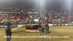 Brady Fielder receives his PBR Billings winner's check and signs autographs for fans