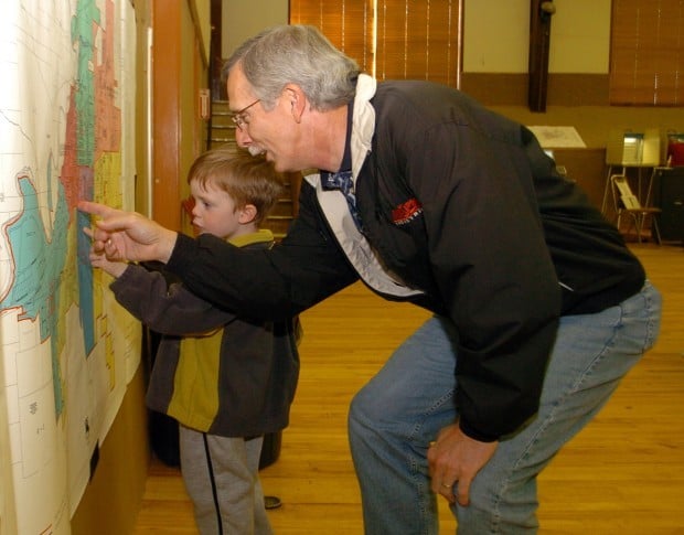 Jeb Beacham and grandson Taylor consult a map of voting precincts