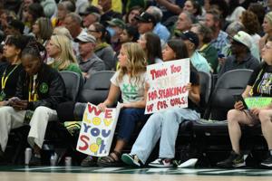 Fans hold a Indiana Fever guard Sophie Cunningham (8) (not pictured) sign during the first half between the Seattle Storm and the Indiana Fever at Climate Pledge Arena. Mandatory Credit: Steven Bisig-Imagn Images