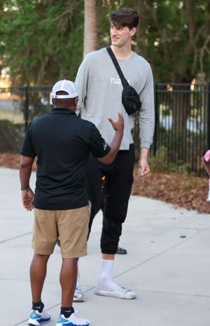 Former Florida basketball center Olivier Rioux chats with fans durning an NCAA softball game at Katie Seashole Pressly Stadium