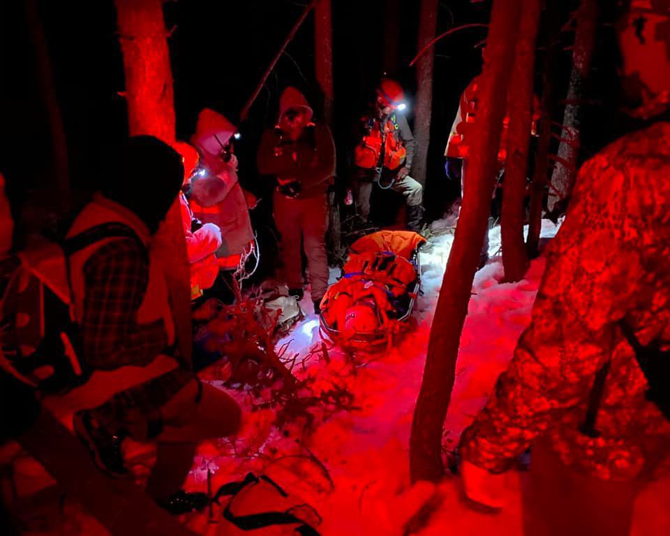 Search and rescue members gather around a man injured while climbing near Nye