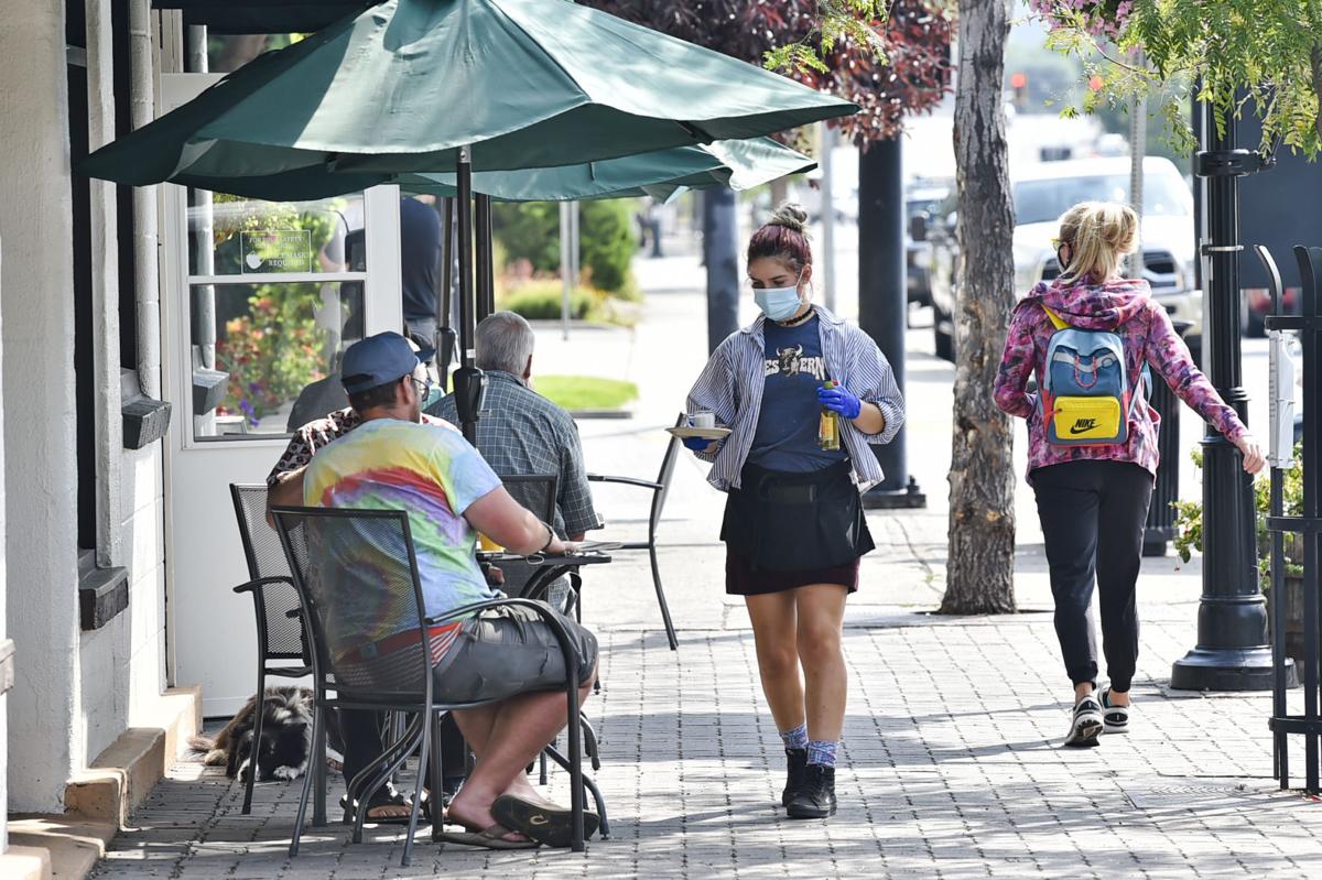 A masked waitress serves drinks and food outside the Western Cafe in Bozeman on Thursday, August 27, 2020.
