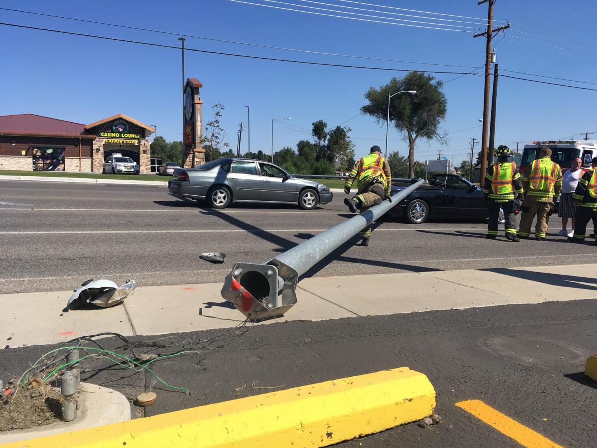 No injuries after light pole topples onto two cars at busy Heights