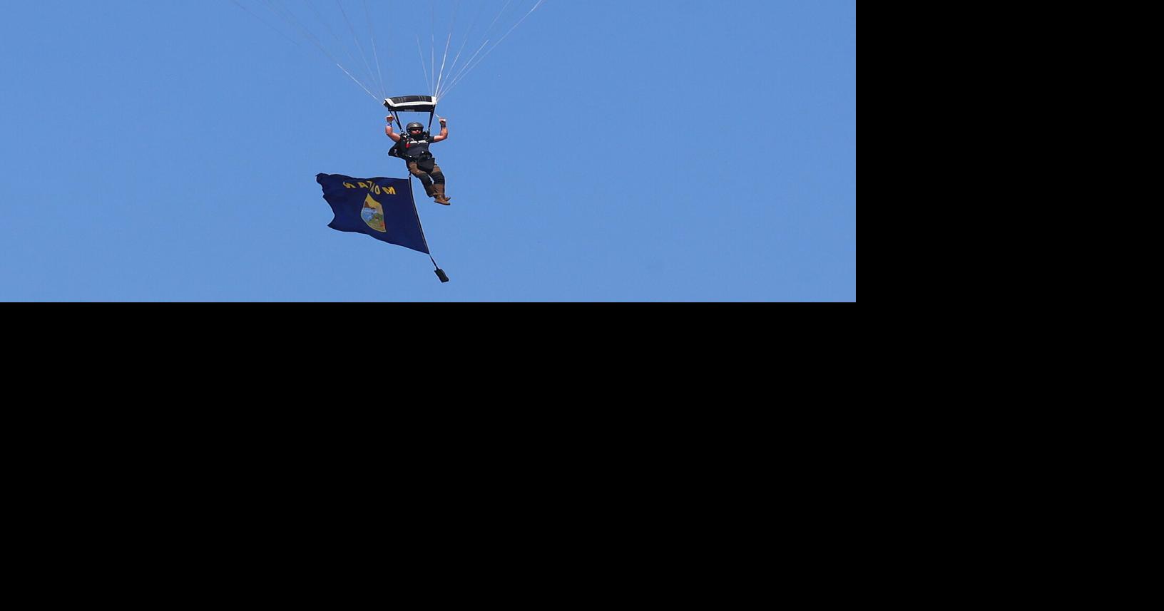 Image for U.S. Senator Tim Sheehy flies a Montana flag as he parachutes into the airshow
