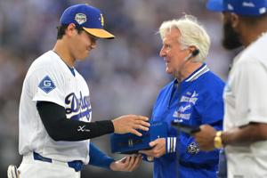 Los Angeles Dodgers player Shohei Ohtani (17) receives his World Series ring from team owner Mark Walter.