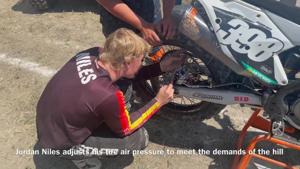 Huntley Project state champion wrestler Jordan Niles makes adjustments to his motorcycle between runs at the Great American Championship Hill Climb