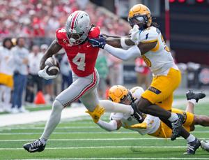 Ohio State Buckeyes wide receiver Jeremiah Smith (4) gets taken down by Kent State Golden Flashes safety Clinton Robinson (38)