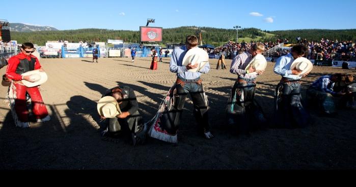 Bull riders remove their hats while a prayer is read