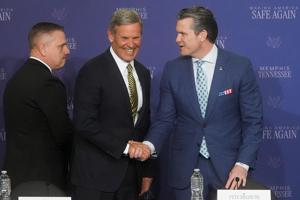 Governor Bill Lee shakes hands with Secretary of War Pete Hegseth as they take the stage as part of a round table with President Donald Trump on the Memphis Safe Task Force inside a hangar at the Memphis Air National Guard Base on March 23, 2026.