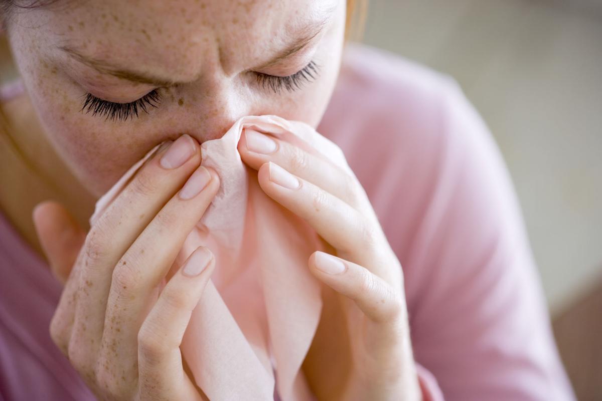 Woman blowing nose