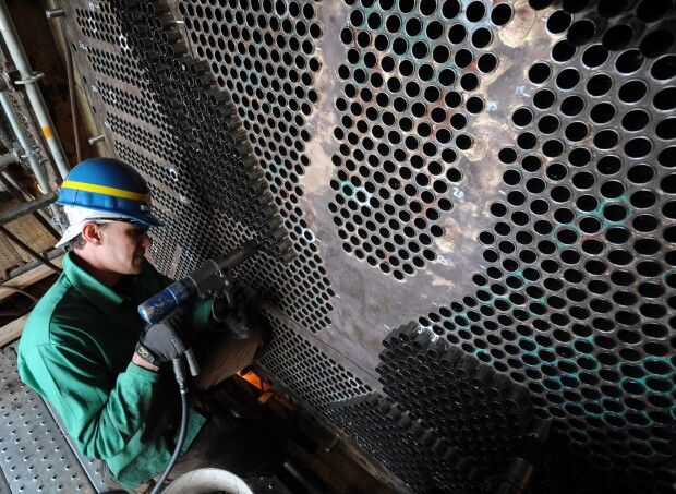 A boilermaker works replacing brass tubing